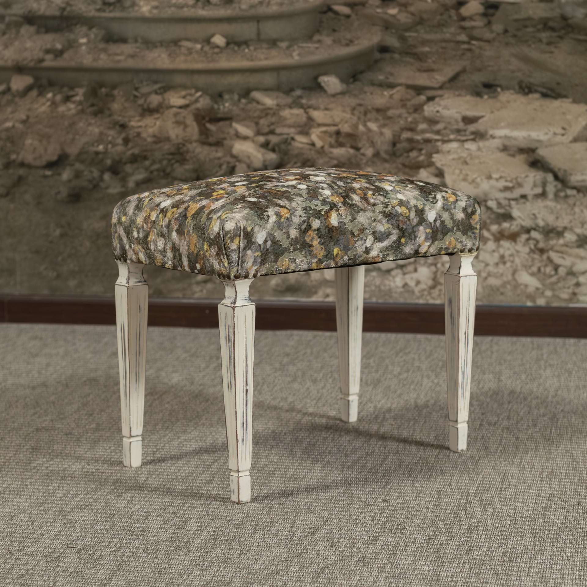 Banco auxiliar, de madera decapada en color lino, tapizado en terciopelo estampado, con remate de tachuela clásica