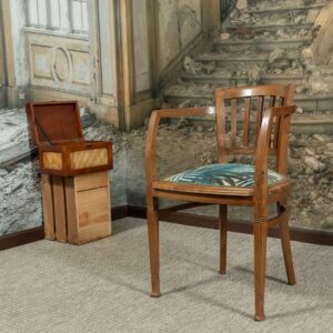 Sillón de madera con brazos, tapizado en tela de lino estampada, con remate de pasamanería de hilo